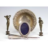 A silver tripod bowl, with florally embossed rim, stamped underside 'Silver' 12cm diameter,