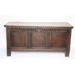 A late 17th century oak coffer, the hinged top with chip carved edge,