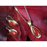 A coral set suite of jewellery, designed as a pear shaped pendant set with a cabochon coral,