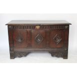 An 18th century and later oak coffer, with hinged top above a triple panelled front,