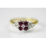 A ruby and diamond ring, designed as four central rubies,