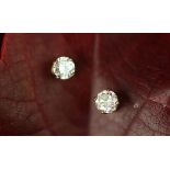 A pair of diamond solitaire earrings, each designed as a round brilliant diamond,