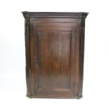 A George III oak hanging corner cabinet, with fluted sides,