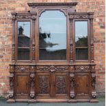 A 19th century French large carved oak bookcase, with three glazed doors enclosing shelves,