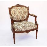 A French carved beech Louis XVI style fauteuil, the cresting rail modelled with musical instruments,