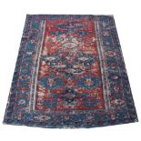 A Caucasian wool rug, worked with geometric motifs against a blue ground,
