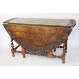 An 18th century oak gate leg table, the oval top with a foliate carved edge,