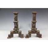A pair of 19th century cast iron fire dogs, decorated with flower heads, on scroll legs,