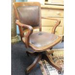 An Edwardian oak office desk chair,