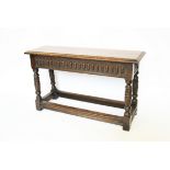 A 17th century style oak long stool, with carved detailing,
