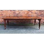 A late Victorian walnut extending dining table, the top with a moulded edge and canted corners,