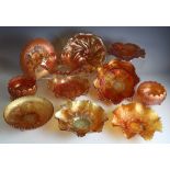 A large selection of marigold carnival glass tripod bowls and shallow dishes,