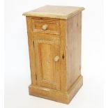 A Victorian pine bedside table, with drawer and cupboard door, on plinth base,