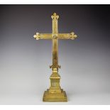 An early 20th century ecclesiastical brass crucifix, upon stepped plinth base,