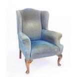 A George III style wing back arm chair, on cabriole legs and pad feet, late 19th century,