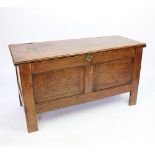 An 18th century oak and walnut coffer, with hinged top above a panelled front with carved date 1762,