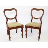 A set of four Victorian dining chairs, with buckle backs and upholstered seats, on turned legs,