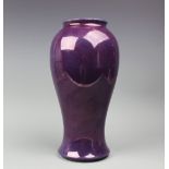 A Moorcroft pottery purple lustre vase, of baluster footed form, unmarked, 30.