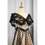 A ballgown of ivory silk satin (bodice & skirt), overlaid with black flower patterned lace,