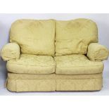 A modern two seater sofa, with floral golden upholstery,