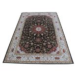 A Kashmir carpet, worked with an all over floral design with a central red medallion,