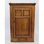 A 19th century pine hanging corner cabinet, with panelled door and drawer,