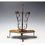 A folk art wrought iron twin branch candle stick, with scroll springs,