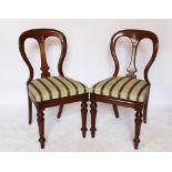 A set of four late Victorian walnut dining chairs, with striped upholstered seats, on turned legs,