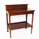 An Edwardian walnut two tier side table, with raised back, on turned legs,
