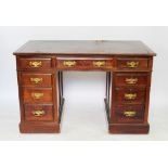 A late Victorian walnut pedestal desk, with leather inset top and an arrangement of nine drawers,
