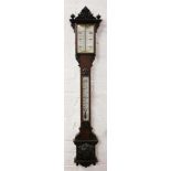 A Victorian carved oak stick barometer, with printed opaque glass scales,
