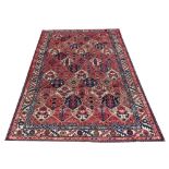 A Caucasian hand woven wool carpet, worked with a panelled floral design,