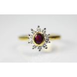 A ruby and diamond cluster ring, the central oval ruby collet set in gold,