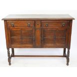 A 1920's oak two door side cabinet, on barley twist legs,