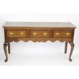 A George III style oak dresser base, with three drawers above a pot shelf, on turned legs,