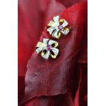 A pair of ruby and diamond set bow shaped earrings, each designed as a central ruby,