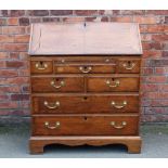 A George III style oak bureau, with fall enclosing a fitted interior, over three short,