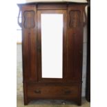 An Arts and Crafts inlaid oak wardrobe, with mirrored door above a long drawer, on bracket feet,