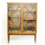 A 19th century bookcase top on later stand, with two astragal glazed doors,