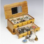 A jewellery box containing a collection of assorted costume jewellery, brooches,
