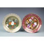 Two Kaizer Porcelain chargers, both printed and painted with flowers, one after Cornelius de Heem,