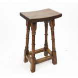 An Arts and Crafts type oak stool on turned legs,