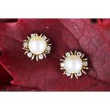 A pair of diamond and pearl cluster earrings, designed as a central untested pearl,