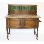 An Edwardian oak wash stand, with green tile back and marble top, above two doors, on turned legs,