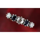 A five stone diamond and sapphire ring, the three old cut diamonds interspersed with two sapphires,