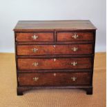 A George III oak and crossbanded chest, of two short and three graduated long drawers,