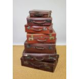 A collection of seven vintage tan leather suitcases, largest 60cm wide,