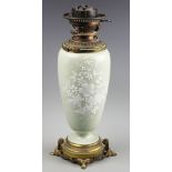 A late 19th century pate sur pate oil lamp, possibly French,