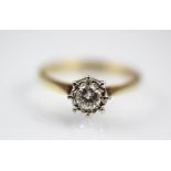 A diamond solitaire ring, the central brilliant cut diamond within an illusion white metal setting,