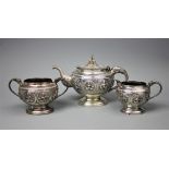 A Burmese silver three piece tea service comprising; a teapot, 14cm high,a twin handled sugar bowl,